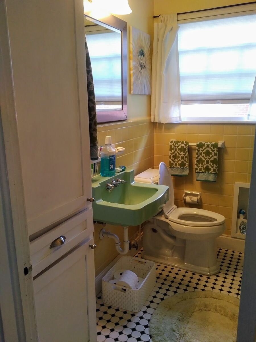 Before: bathroom with yellow wall tile, a wall-hung green sink, and an octagon mosaic floor